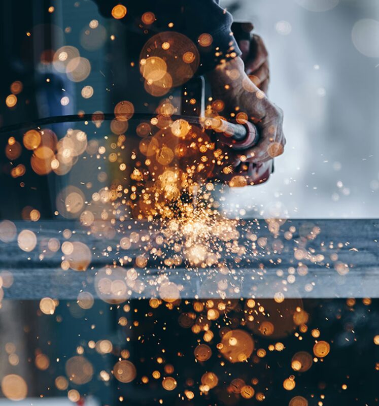 Szlifowanie elementu stalowego z intensywnymi iskrami podczas obróbki metalu