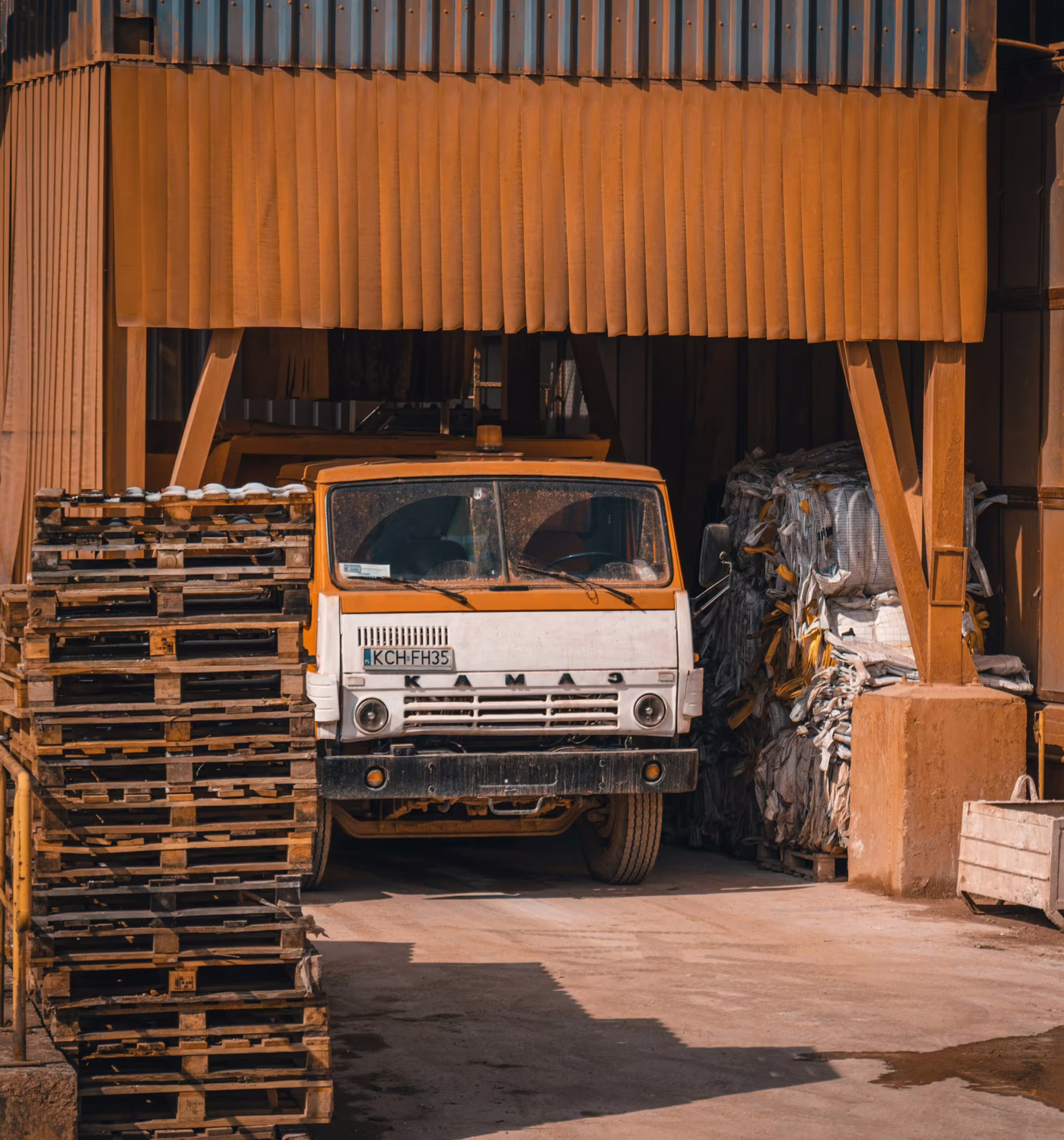 Ciężarówka i palety przed halą magazynową — zaplecze logistyczne sklepu Acerado z osprzętem do maszyn budowlanych